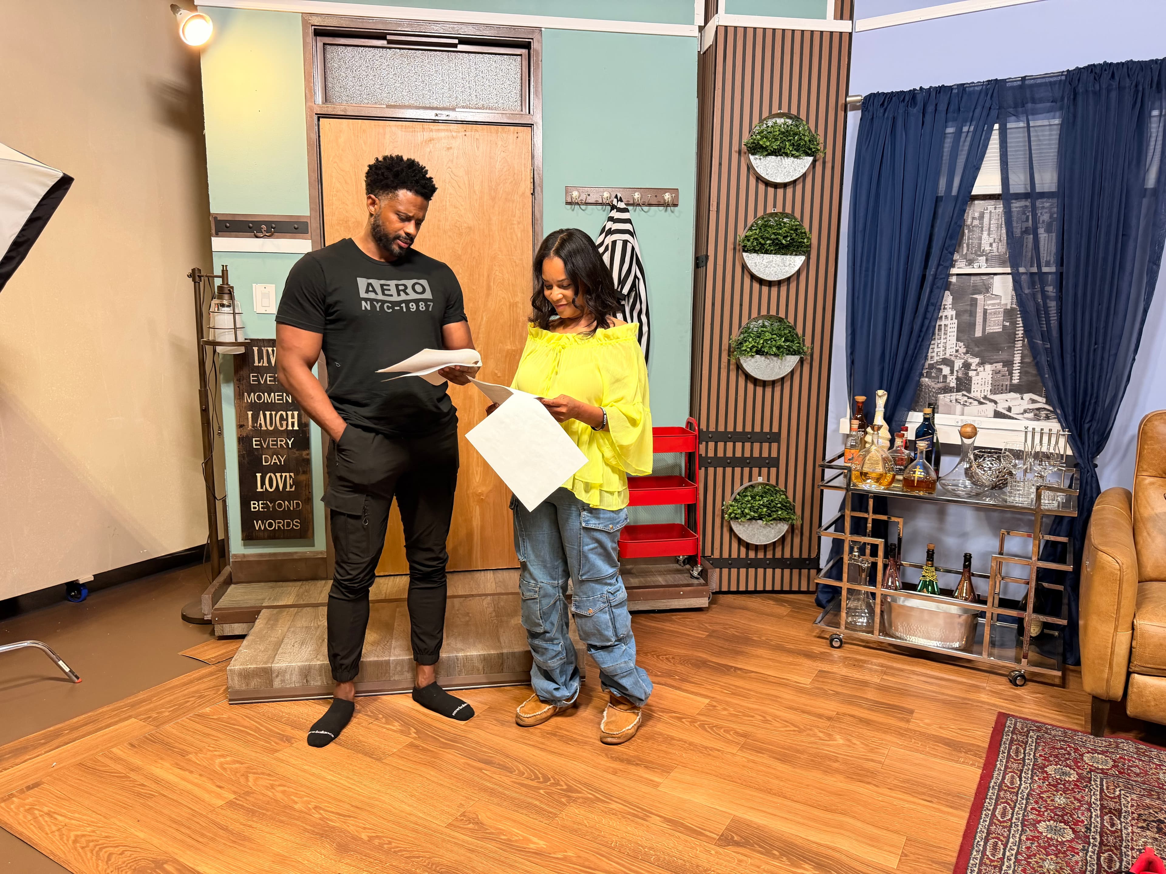 Two actors reading through a scene together on the living room set