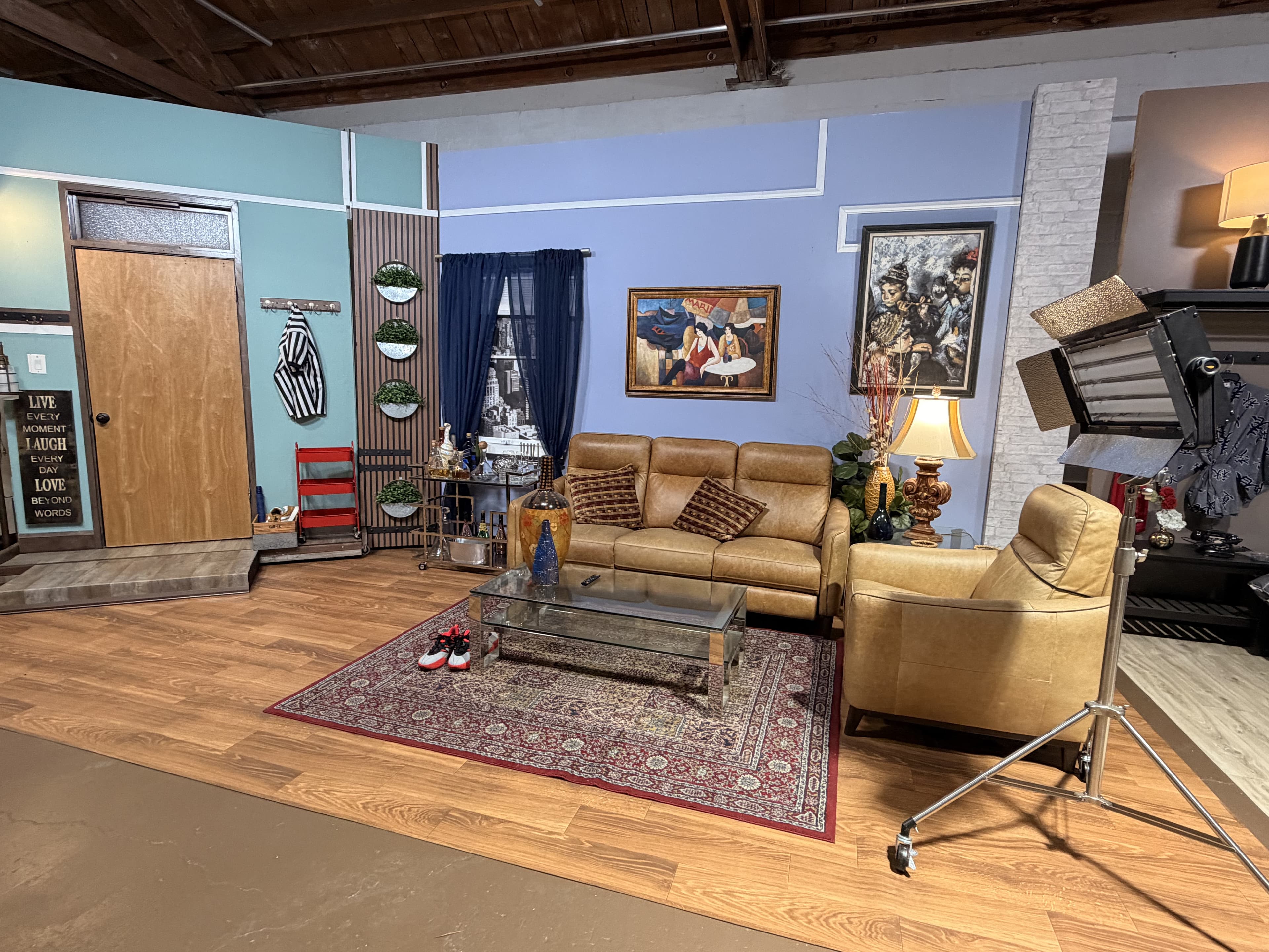 The living room standing set, wide angle: leather sofas, wardrobe door, and dressed walls